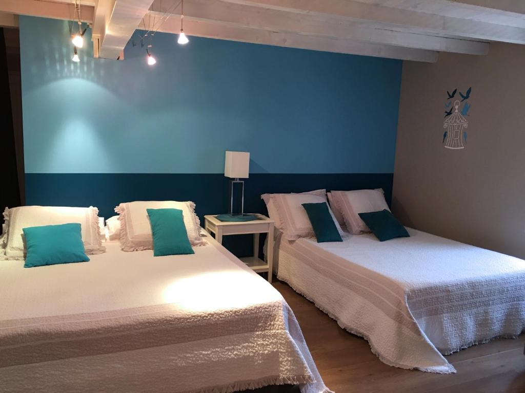 2 Betten in einem Zimmer mit blauen Wänden in der Unterkunft Les Chambres d'Hôtes d'Alice Dior in Blacé