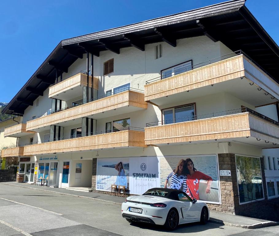 een witte auto geparkeerd voor een gebouw bij Posthof 37 in Kitzbühel