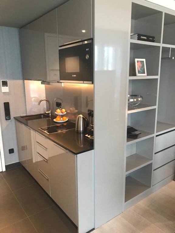 a kitchen with white cabinets and a black counter top at Sky Aparthotel in Stuttgart