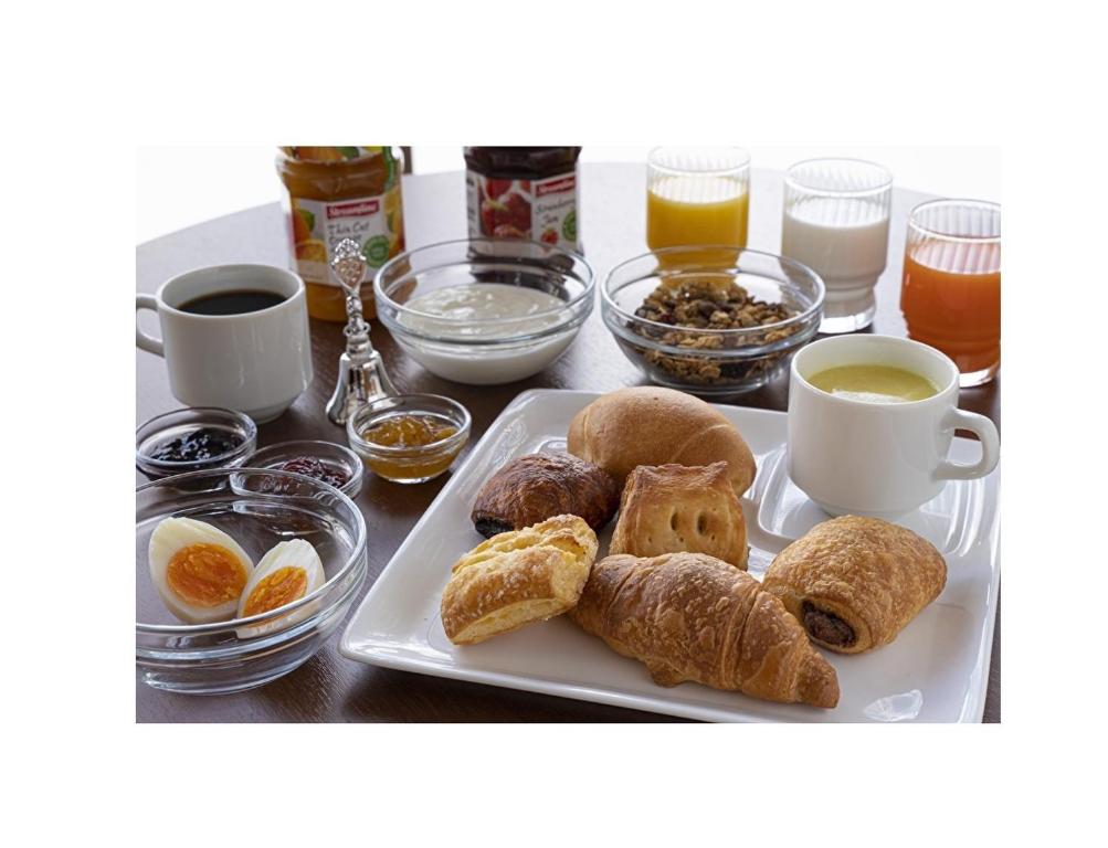 a table with a plate of pastries and cups of coffee at R&B Hotel Nagoya Nishiki - Vacation STAY 37477v in Nagoya