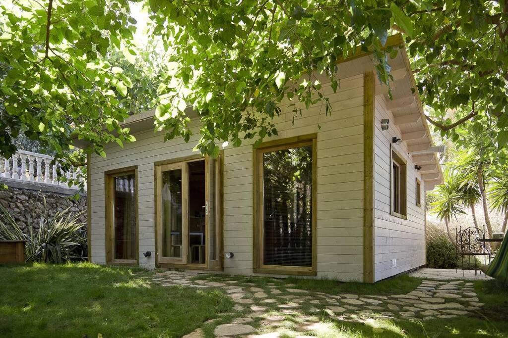 una pequeña casa con revestimiento amarillo y un patio en Les Moreres, en Gandía