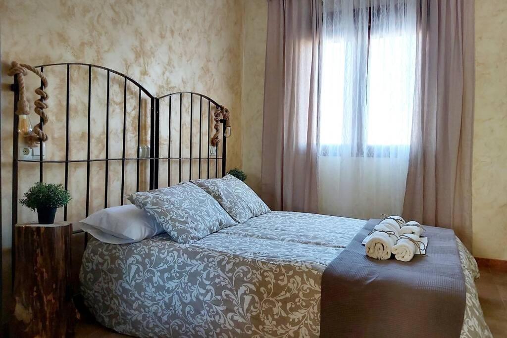 1 dormitorio con 1 cama con 2 toallas en La Morada de los Olmos en Segovia