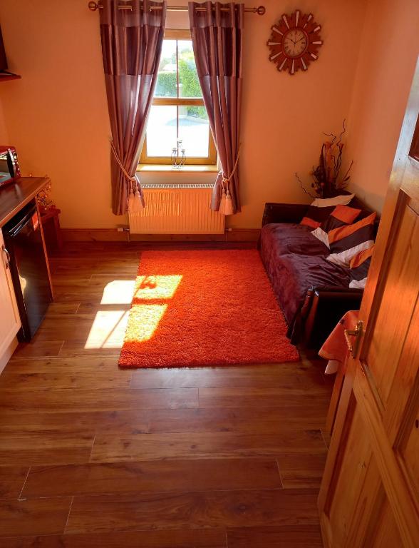 a living room with a couch and a window at A New U Country Cottage Apartment 2 in Valentia Island
