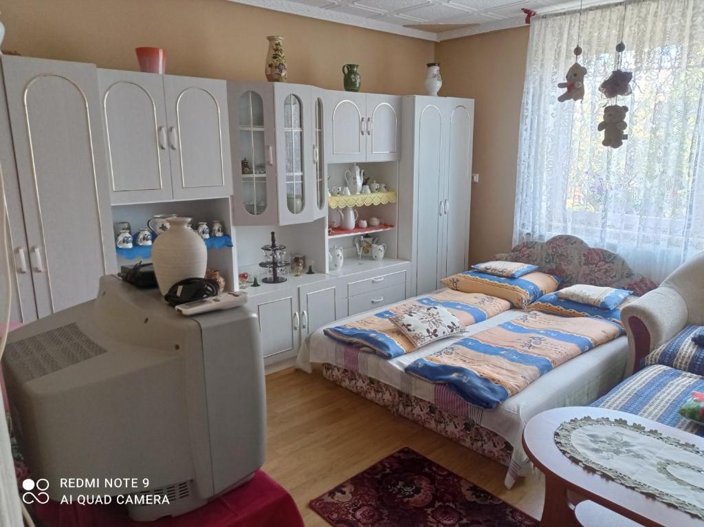 a childs bedroom with a bed and a cabinet at Olga Vendégház in Abádszalók