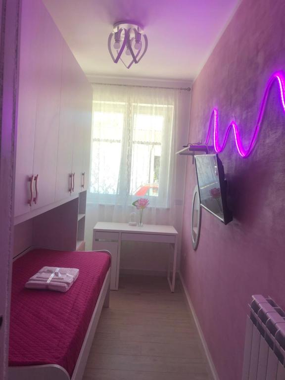een kamer met een bed en een paarse muur met neonlichten bij Palinuro Centro in Palinuro