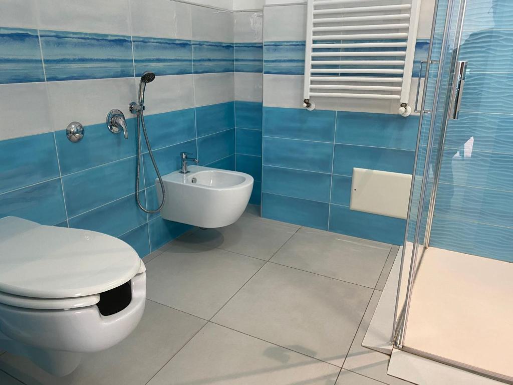 a blue and white bathroom with a toilet and a shower at 103 Boutique Hotel Stintino in Stintino