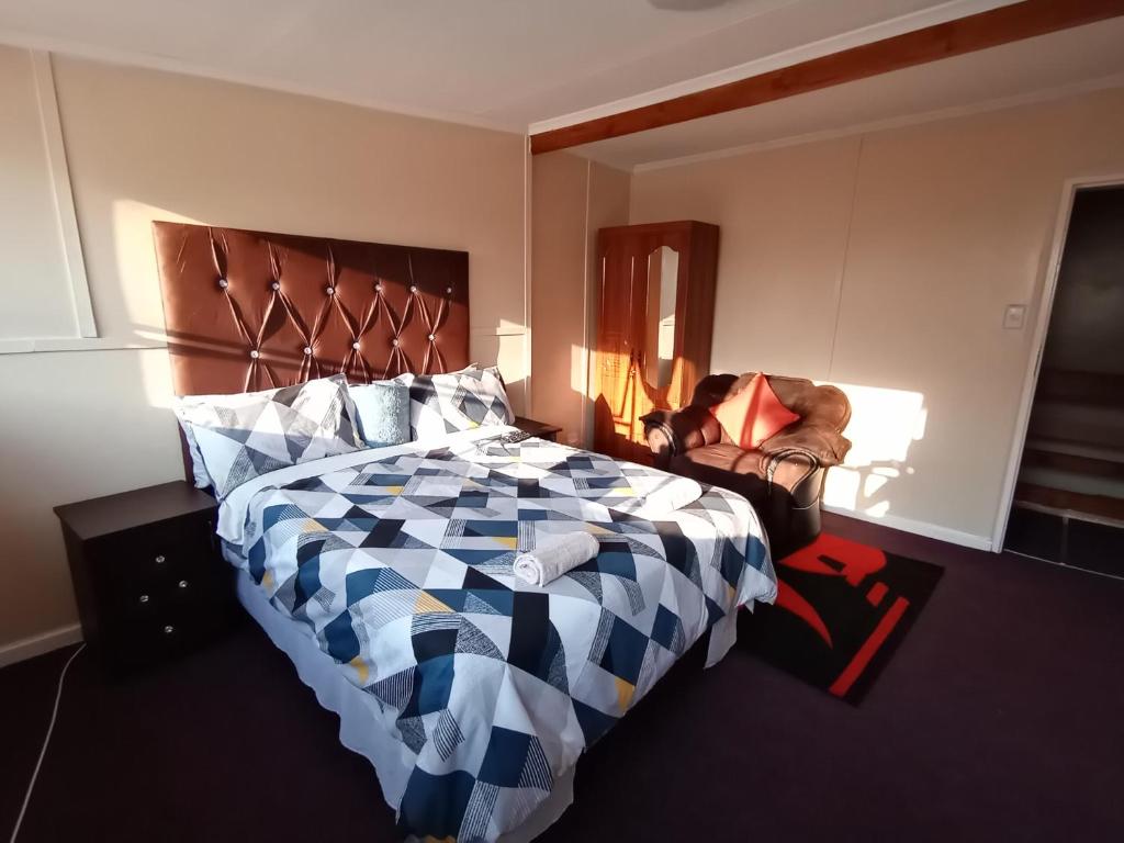 - une chambre avec un lit et une chaise dans l'établissement MOFFAT GUEST HOUSE, à Randfontein