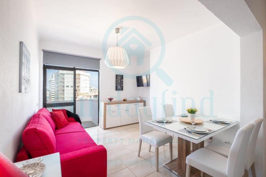 een woonkamer met een rode bank en een tafel bij Apartment Algarve - Beach Front - Free Wifi - Air Con in Armação de Pêra