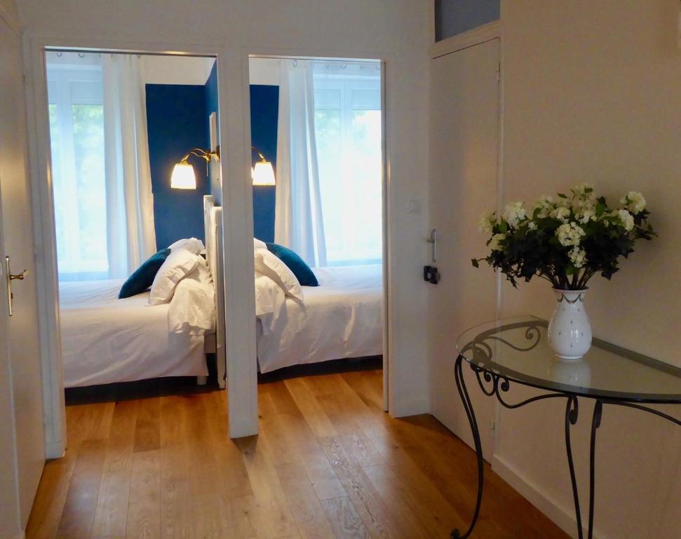 a bedroom with a bed and a table and a mirror at La Lavandière in Puimoisson