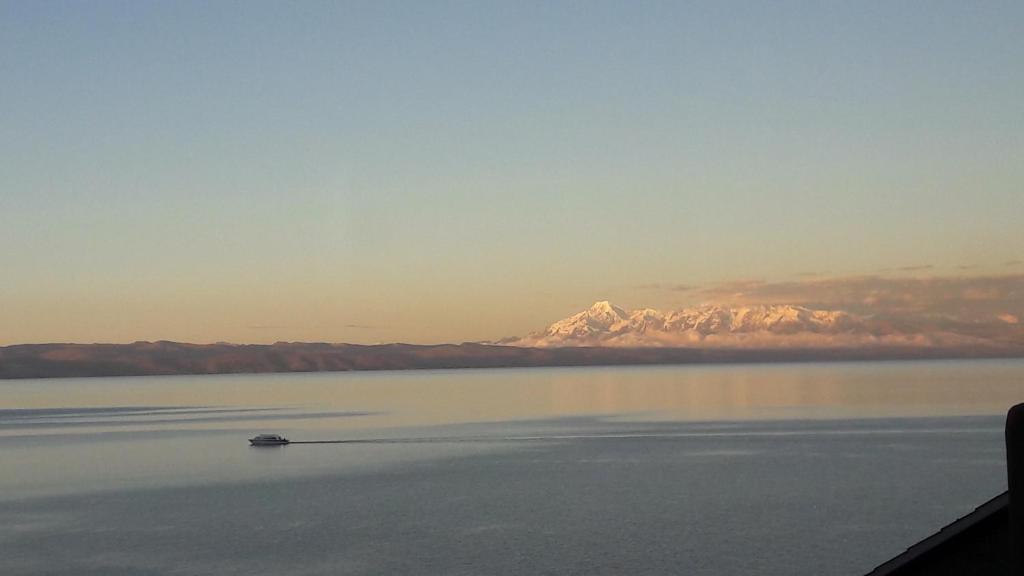 a boat in the water with a mountain in the background at JACHA INTI in Isla de Sol