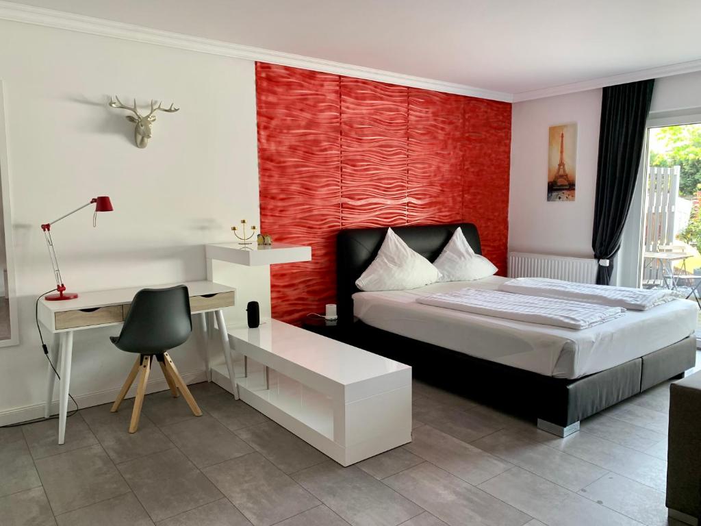 a bedroom with a bed with a desk and a red wall at Apartment Martinstraße 7b in Hannover