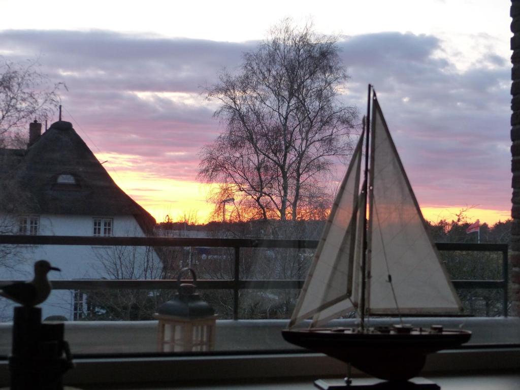 un pequeño velero sentado en un alféizar de la ventana en Oland Whg 10 Südstrandperle, en Wyk auf Föhr