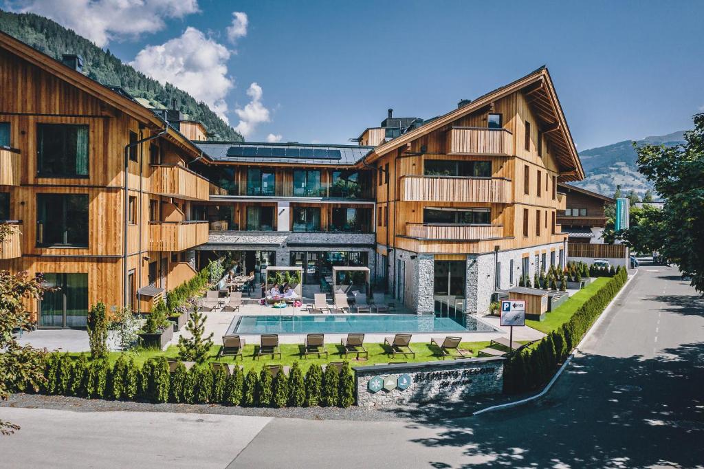 a building with a swimming pool in front of it at Elements Resort Zell am See; BW Signature Collection in Zell am See