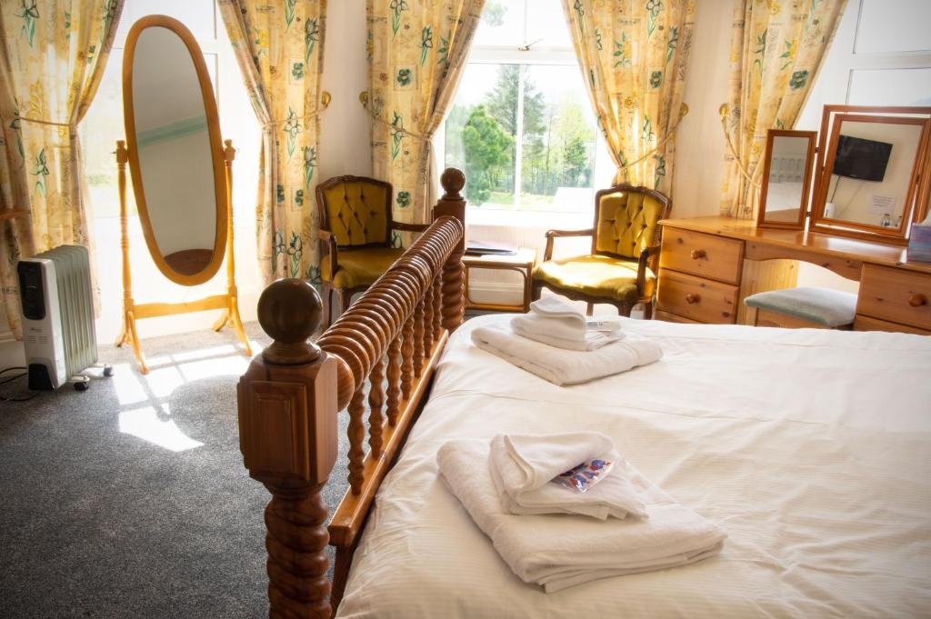 1 dormitorio con 2 camas y un espejo grande en isallt guesthouse, en Blaenau Ffestiniog