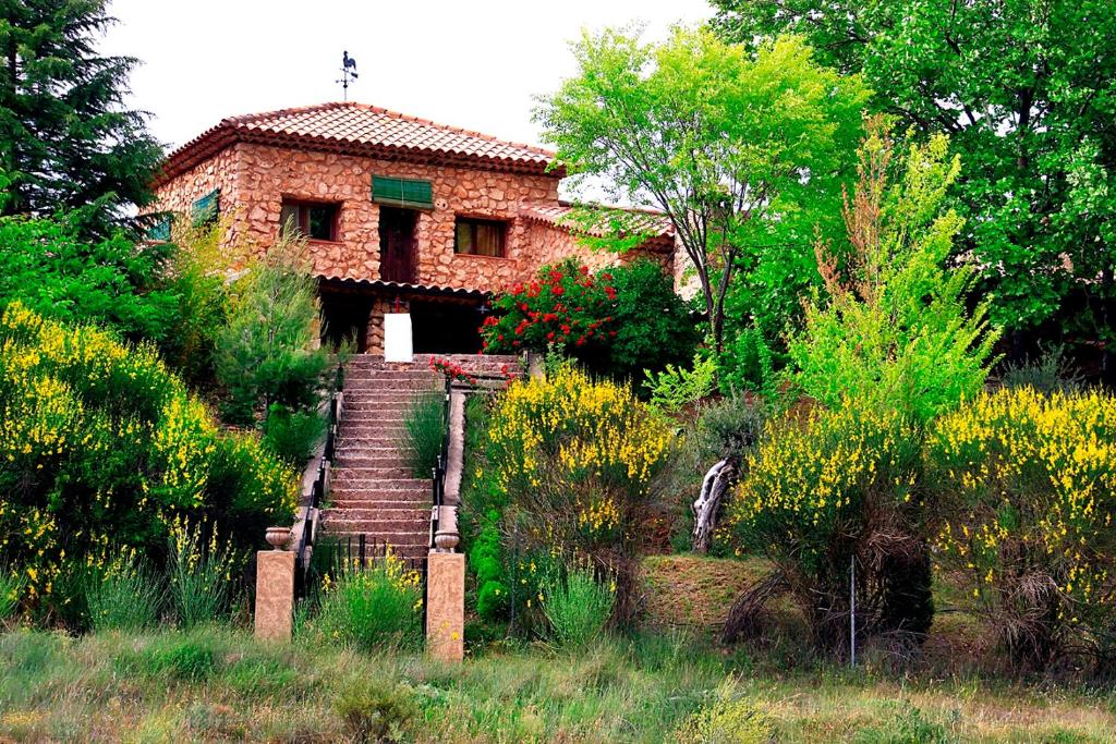 une maison en briques avec un escalier dans un jardin dans l'établissement Royo Guarde, junto al río Mundo, à Riópar