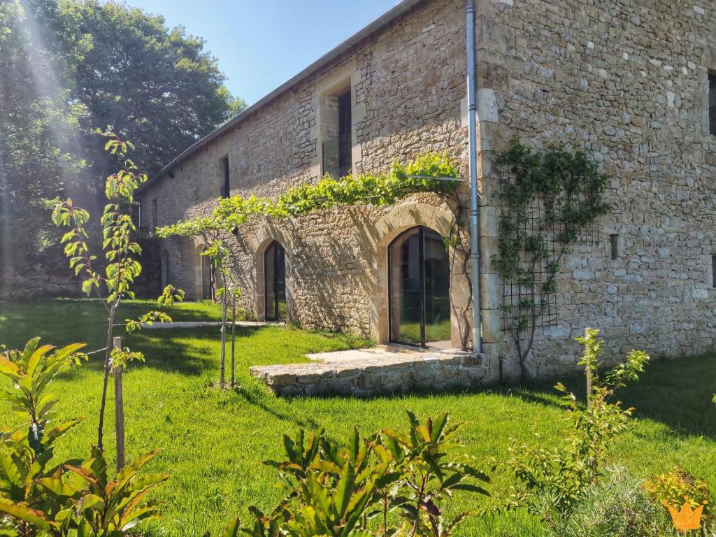 an old brick building with vines growing on it at Estafête in Sarrazac