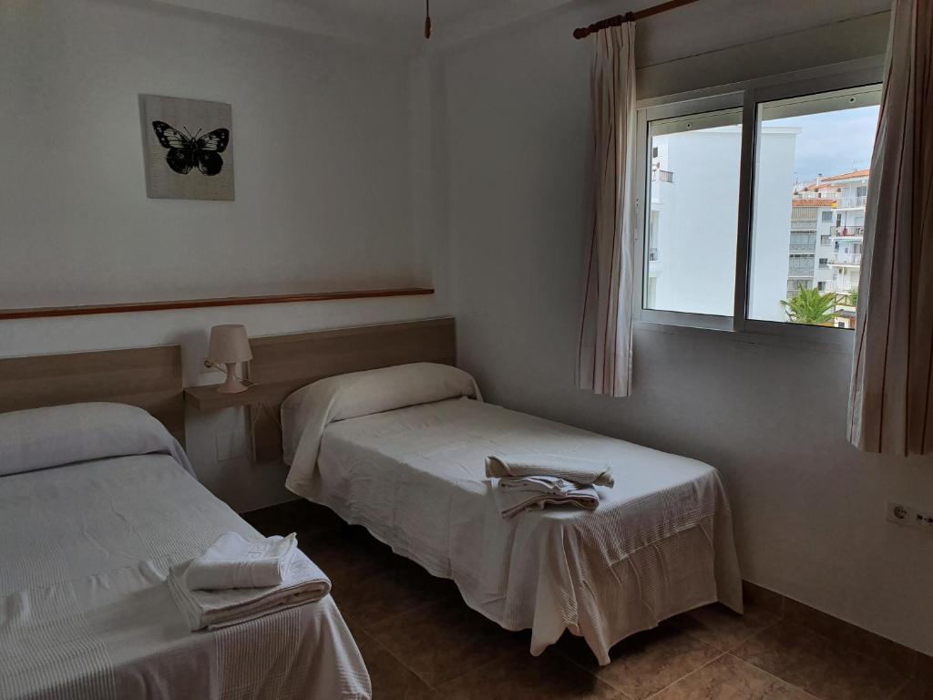 Habitación de hotel con 2 camas y ventana en 2ºA Escobar, en Nerja