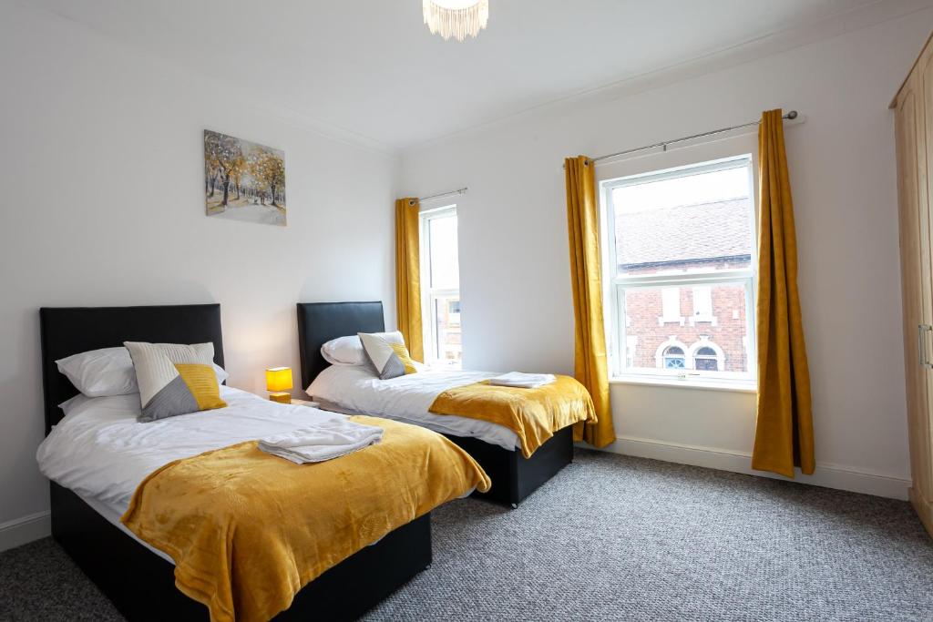 a bedroom with two beds and a window at Inspired Stays-City Centre Location- Sleeps up to 9 in Stoke on Trent