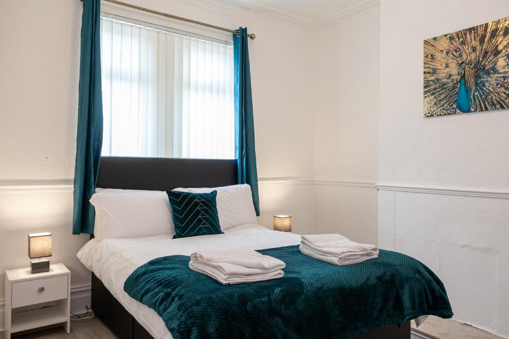 1 dormitorio con 1 cama con 2 toallas en Inspired Stays-City Centre Location- Sleeps up to 9 en Stoke on Trent