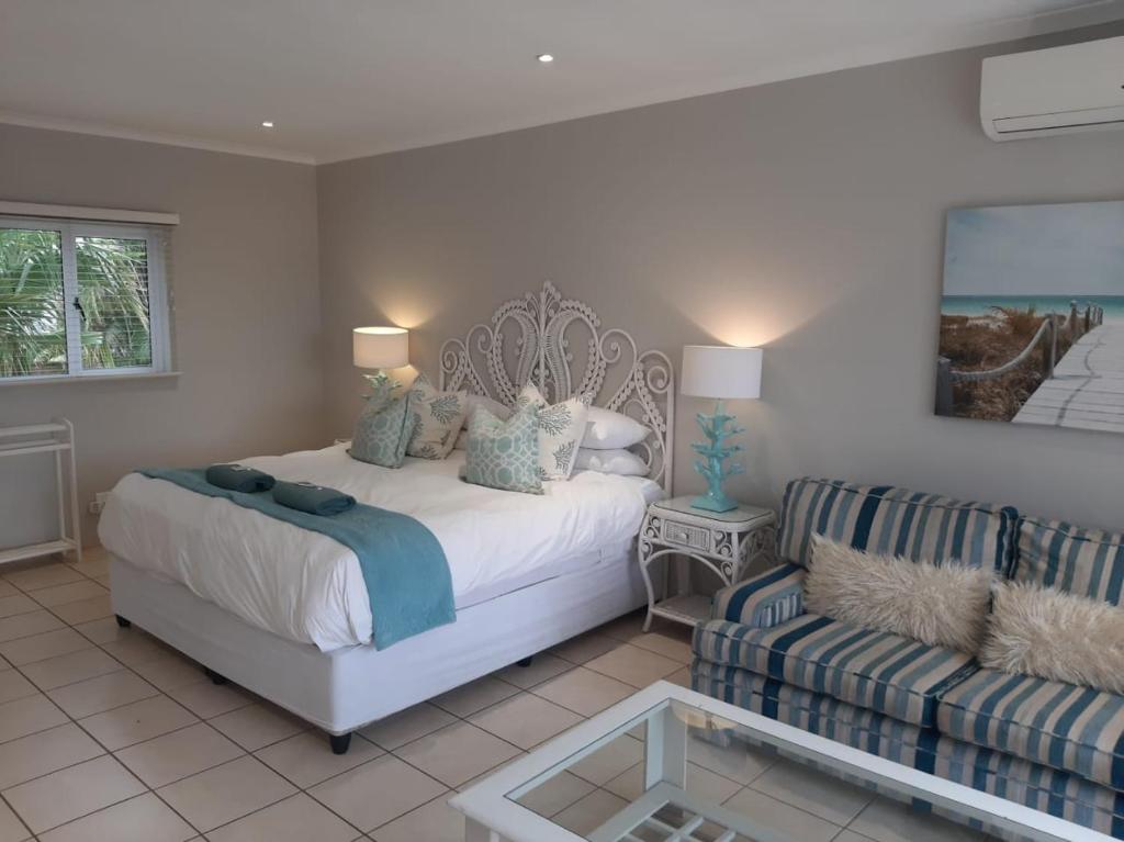 1 dormitorio con 1 cama y 1 sofá en 8 Oyster, en Durban