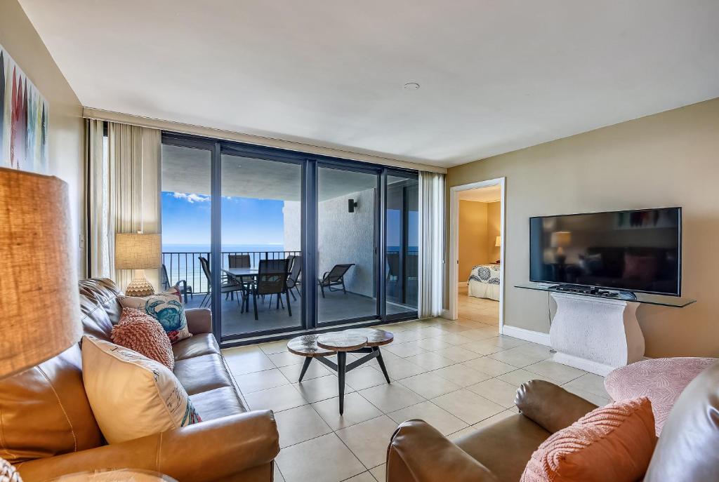 uma sala de estar com um sofá e uma televisão em Watercrest #1206 by Book That Condo em Panama City Beach