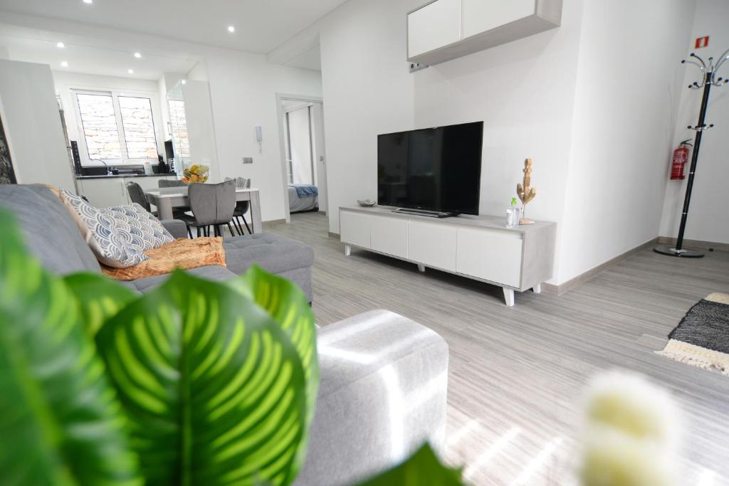 ein Wohnzimmer mit einem Sofa und einem Flachbild-TV in der Unterkunft Casas do Baleeiro - Whaler's Houses in Caniçal