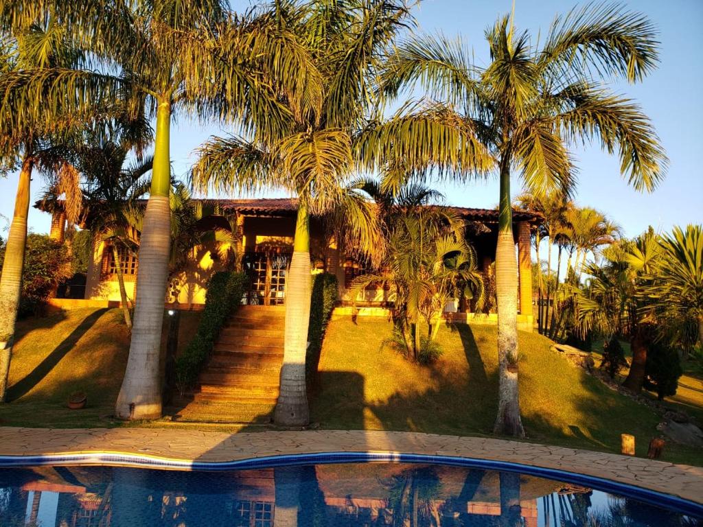 um resort com palmeiras e uma piscina em Chácara Rancho da Coruja em Itu