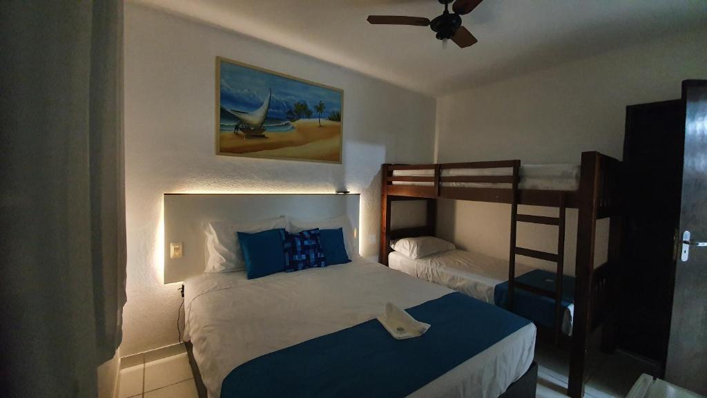 a bedroom with a bed and a bunk bed at Recanto Isla Pousada in Ubatuba