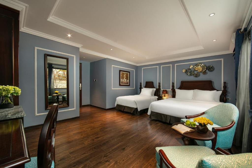 Postel nebo postele na pokoji v ubytování Romantique Hotel De Hanoi