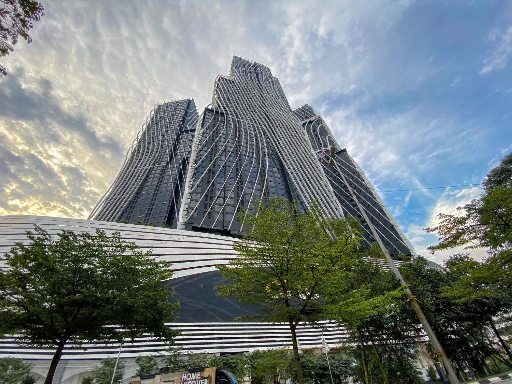 a tall building with trees in front of it at Arte Mont Kiara by CozyNest in Kuala Lumpur