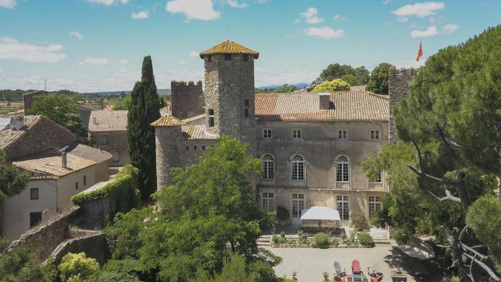 un antiguo castillo en una ciudad con árboles en Château d'Agel chambres d'hôtes, en Agel