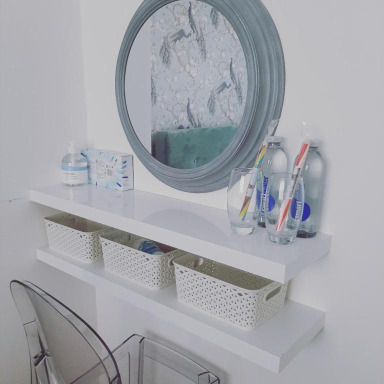 a white shelf with a mirror and some glasses at Home from Home Stay Margate in Margate