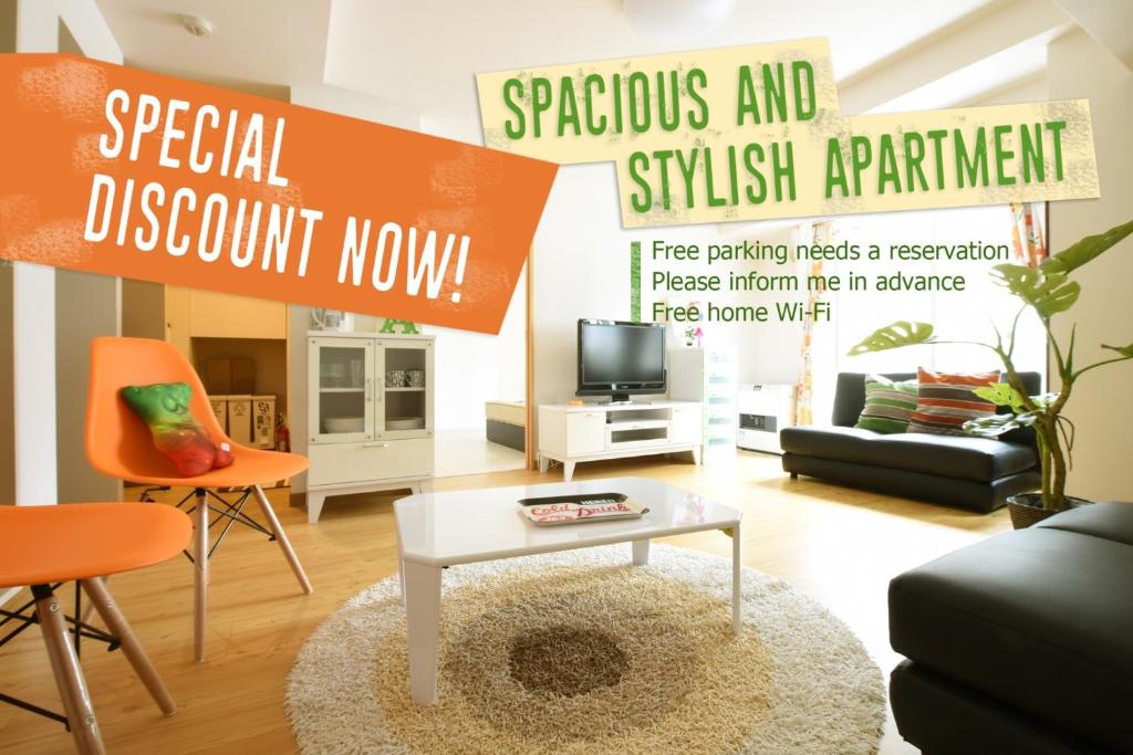 a living room with a white coffee table and orange chairs at AMS Tower Nakajima Room 505 - Vacation STAY 8388 in Sapporo