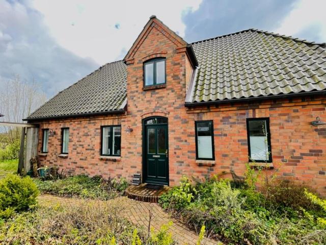 an old brick house with a black door at Gästehaus Zum Krug in Husum