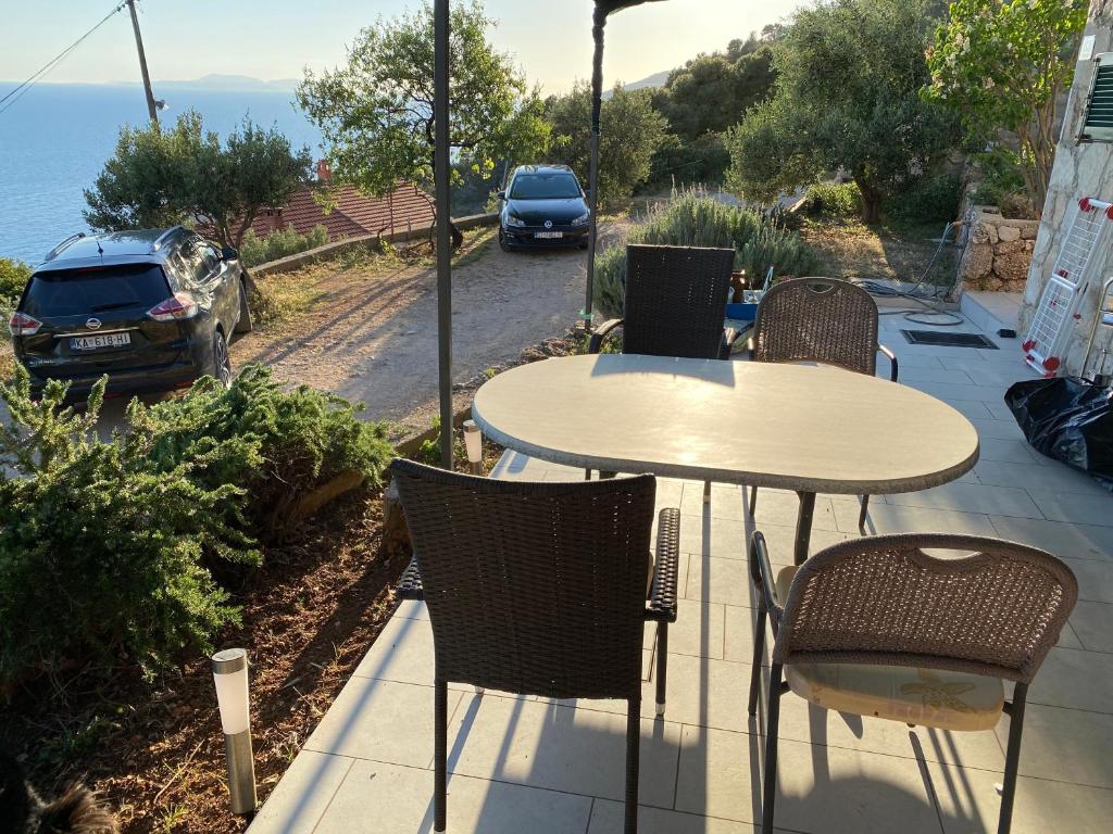 a table and chairs on a patio with a view of the ocean at Apartments Vila Vino in Sveta Nedelja