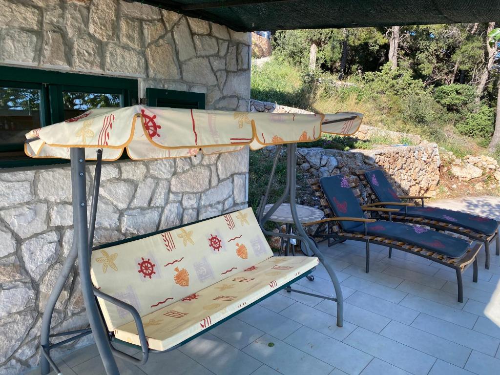 a table and chairs under an umbrella on a patio at Apartments Vila Vino in Sveta Nedelja