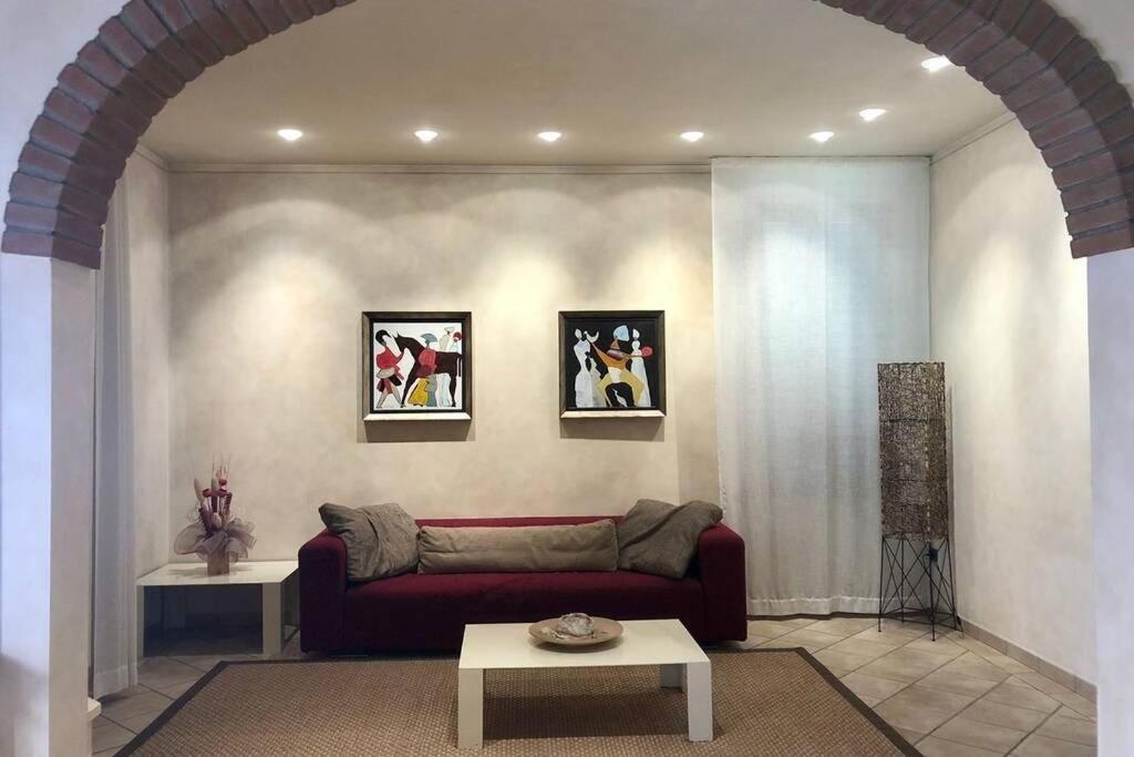 uma sala de estar com um sofá vermelho e uma mesa em Bella casa vicino alla grotta giusti. em Monsummano