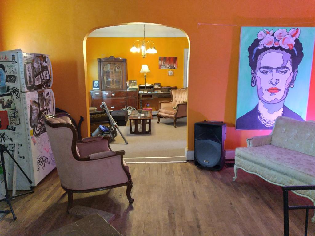a living room with a painting of a man on the wall at Art House Detroit Creative in Detroit