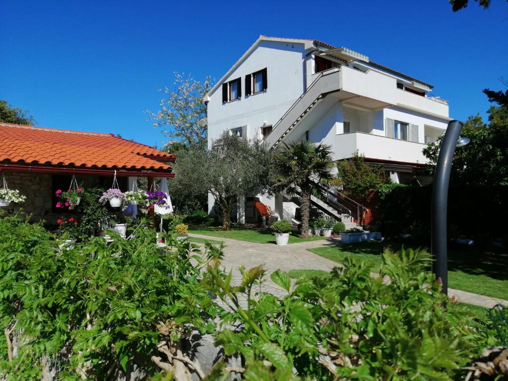 une maison blanche avec un toit rouge dans l'établissement Apartments "Mulo" beachfront, à Vrsi