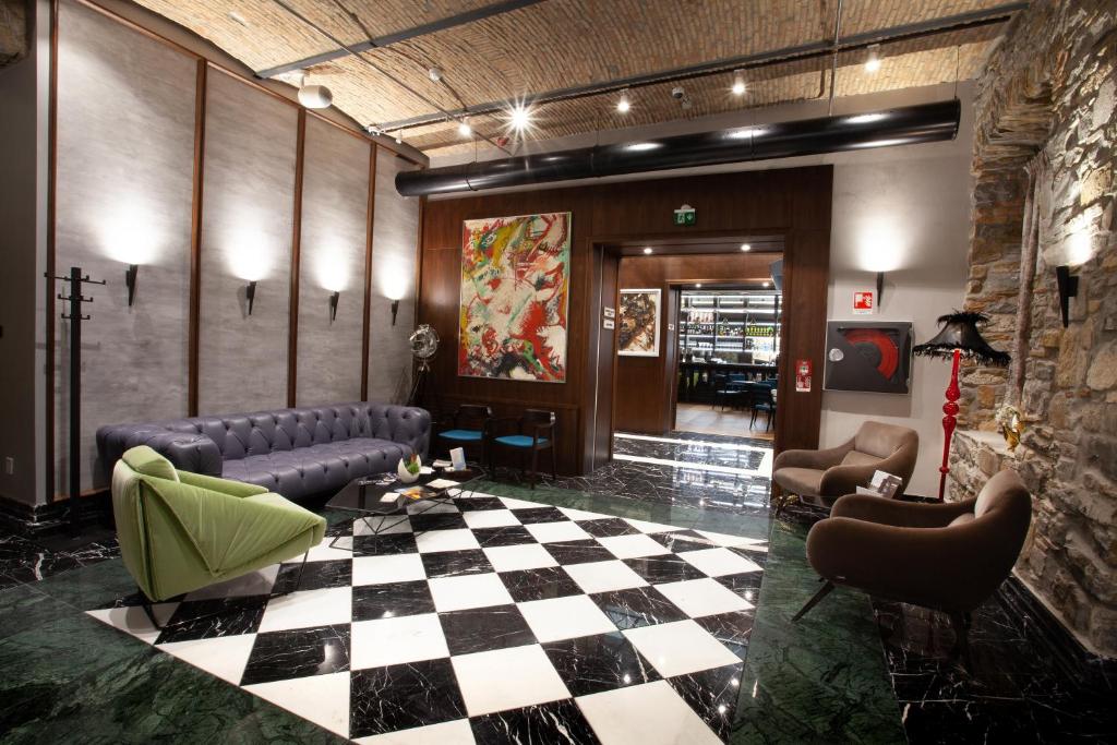 a lobby with a checkered floor and couches at Hotel Solun in Trieste