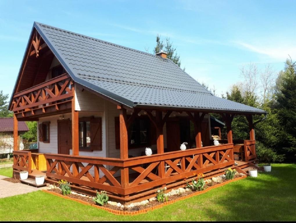 a large wooden gazebo with a black roof at Zakątek Wenantego in Kopalino