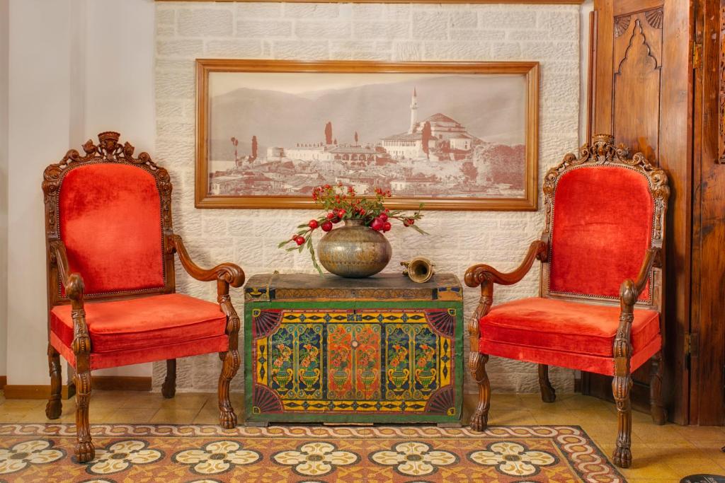 two chairs and a table with a vase in a room at ARCHONTARIKI Historic Boutique Hotel in Ioannina