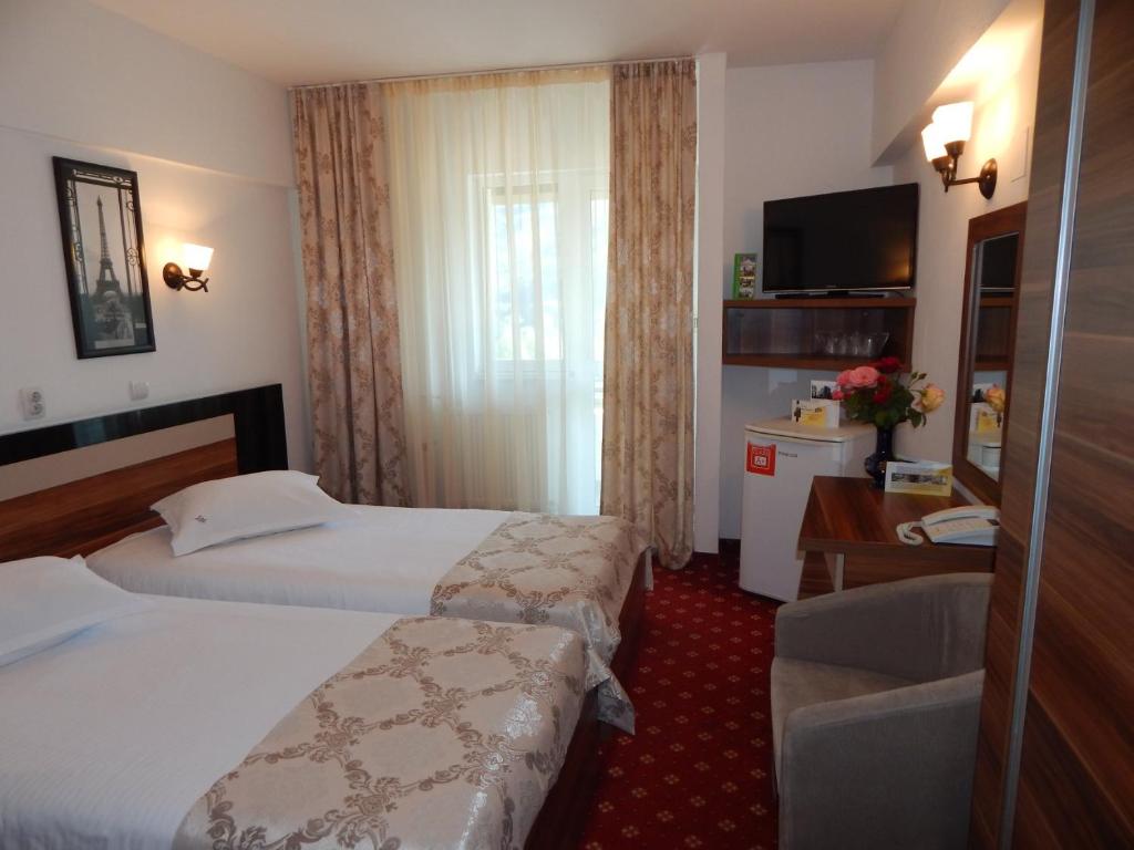 Postel nebo postele na pokoji v ubytování Hotel Traian Caciulata