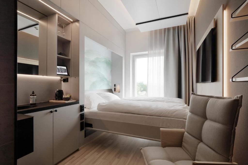 a bedroom with a bed and a window at VALO Hotel & Work Helsinki in Helsinki