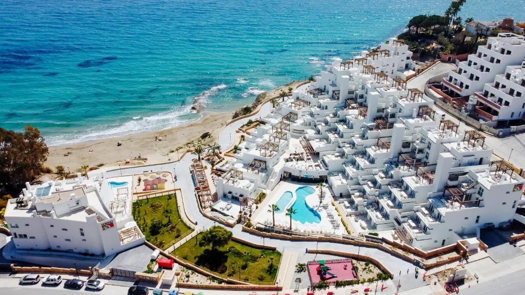 Dormio Resort Costa Blanca Beach & Spa في إل كامبيلو: اطلالة جوية على شاطئ مباني بيضاء