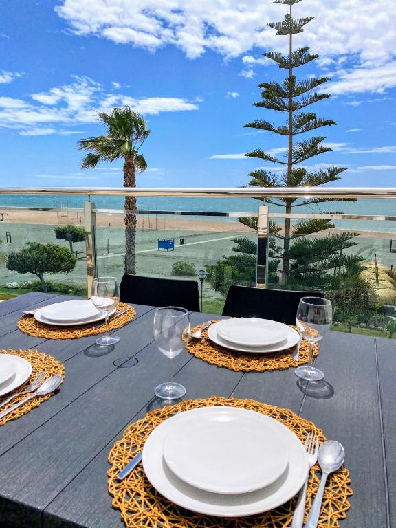 a table with glasses and plates on a table with a view at APARTAMENTO JMHR 4 in Benajarafe