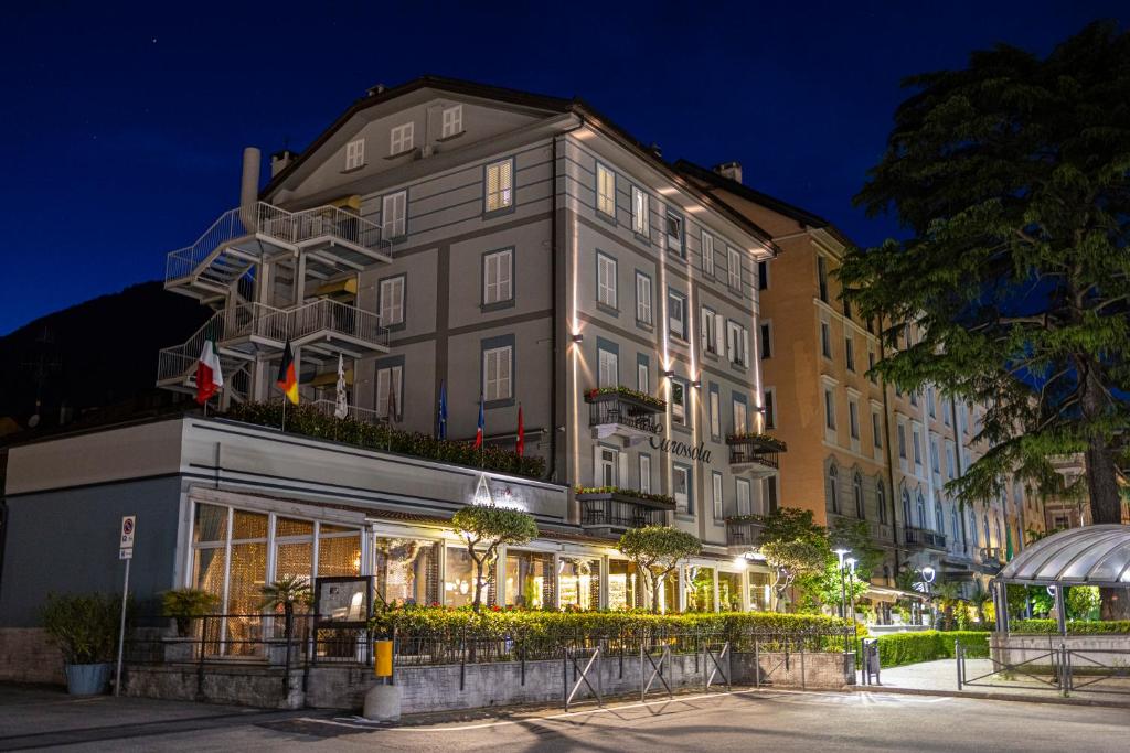 a tall building with a store front at night at Hotel Ristorante Eurossola in Domodossola