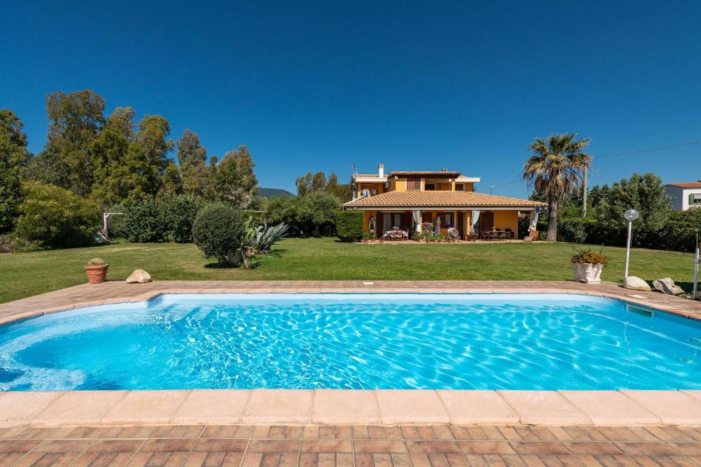 a swimming pool in front of a house at Masone Murgioni in Castiadas