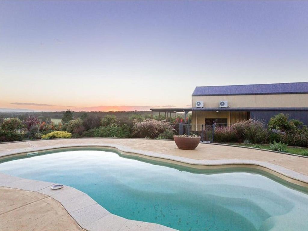 a swimming pool in front of a house at Kelman Cottage with pool and beautiful native wildlife in Belford