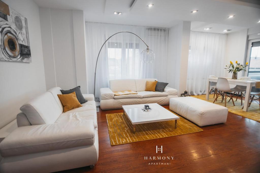 a living room with a white couch and a table at Harmony Apartmani Arandjelovac in Arandelovac